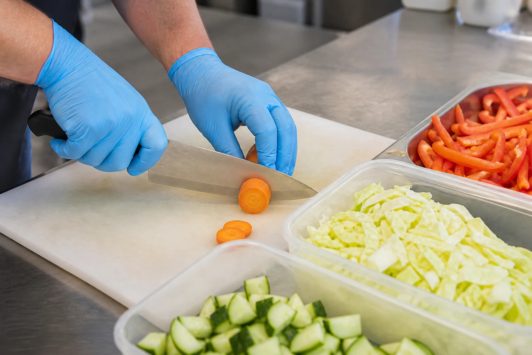 Behandschuhte Hände bei der hygienischen Verarbeitung frischer Convenience-Produkte